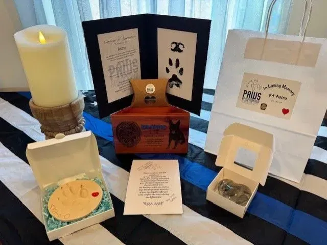 A candle is sitting on top of a table surrounded by boxes and cards.