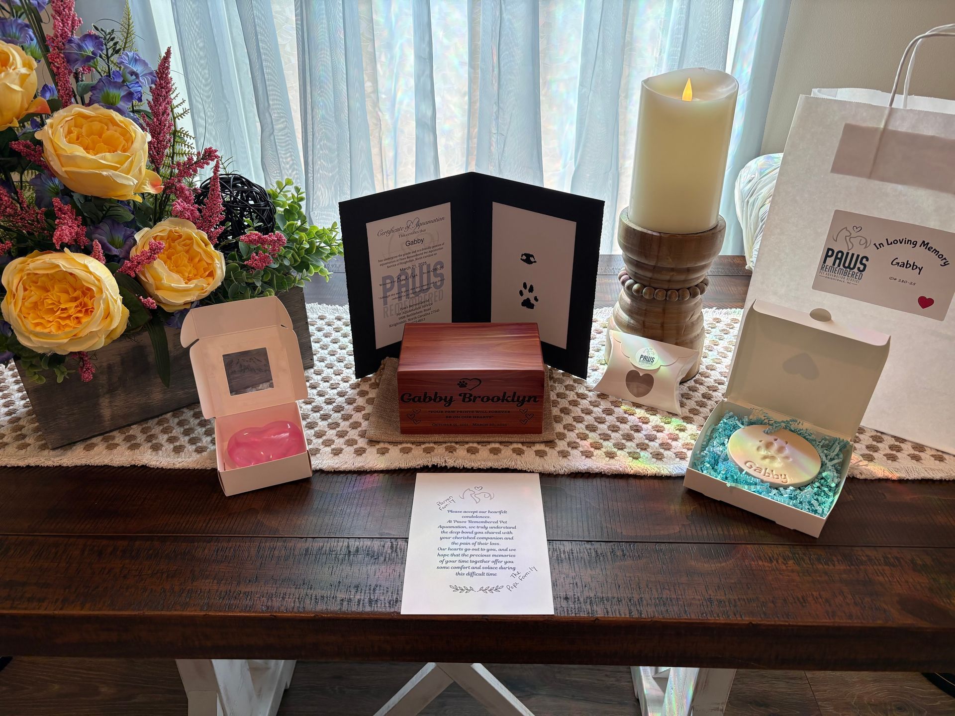 A wooden table with a bunch of boxes and a candle on it.