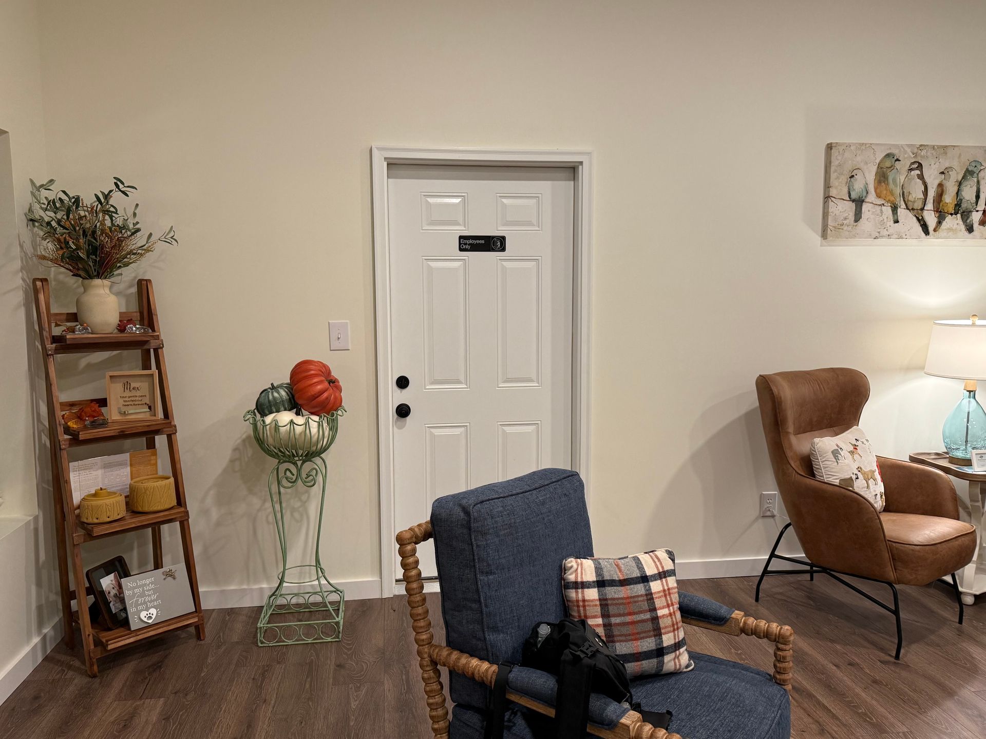 A living room with two chairs , a ladder , and a door.