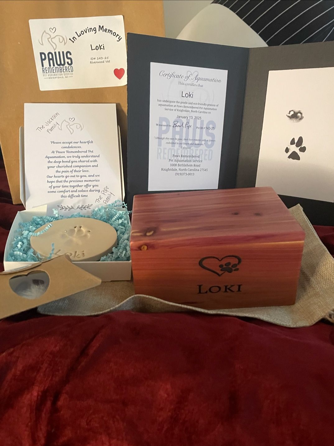 A wooden box with a heart on it is sitting on a bed.