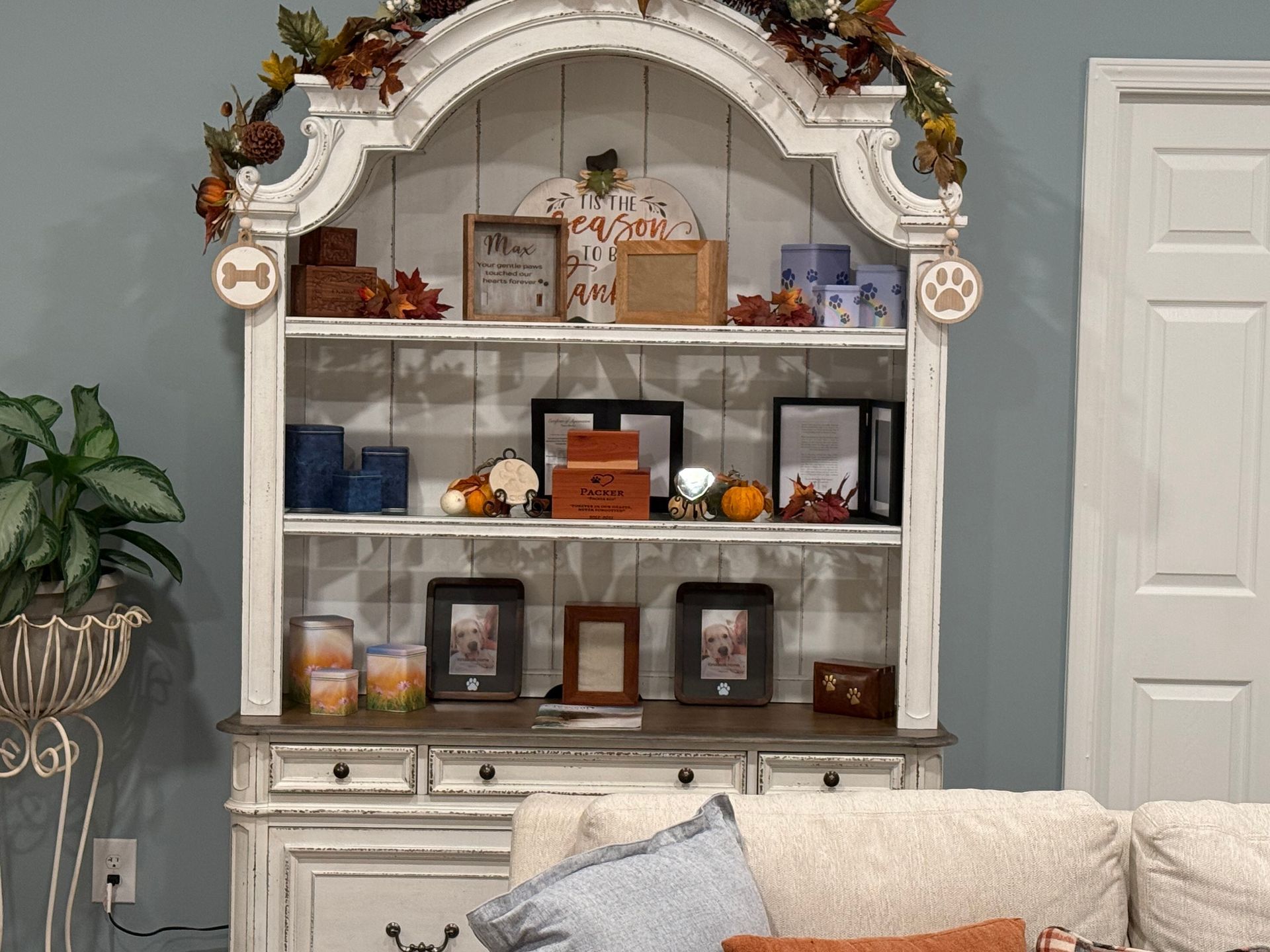 A living room with a white hutch and a couch.