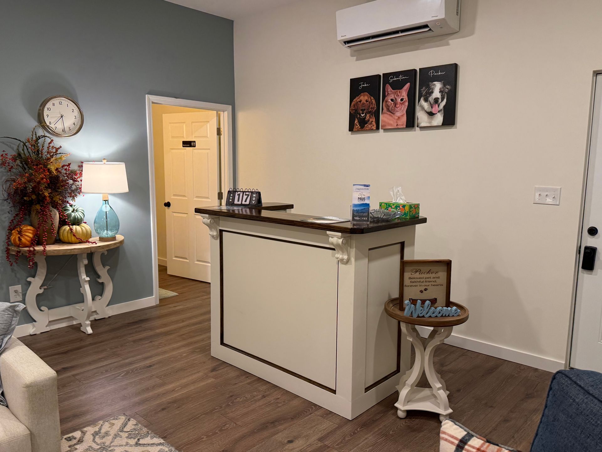 A living room with a white counter and a clock on the wall.