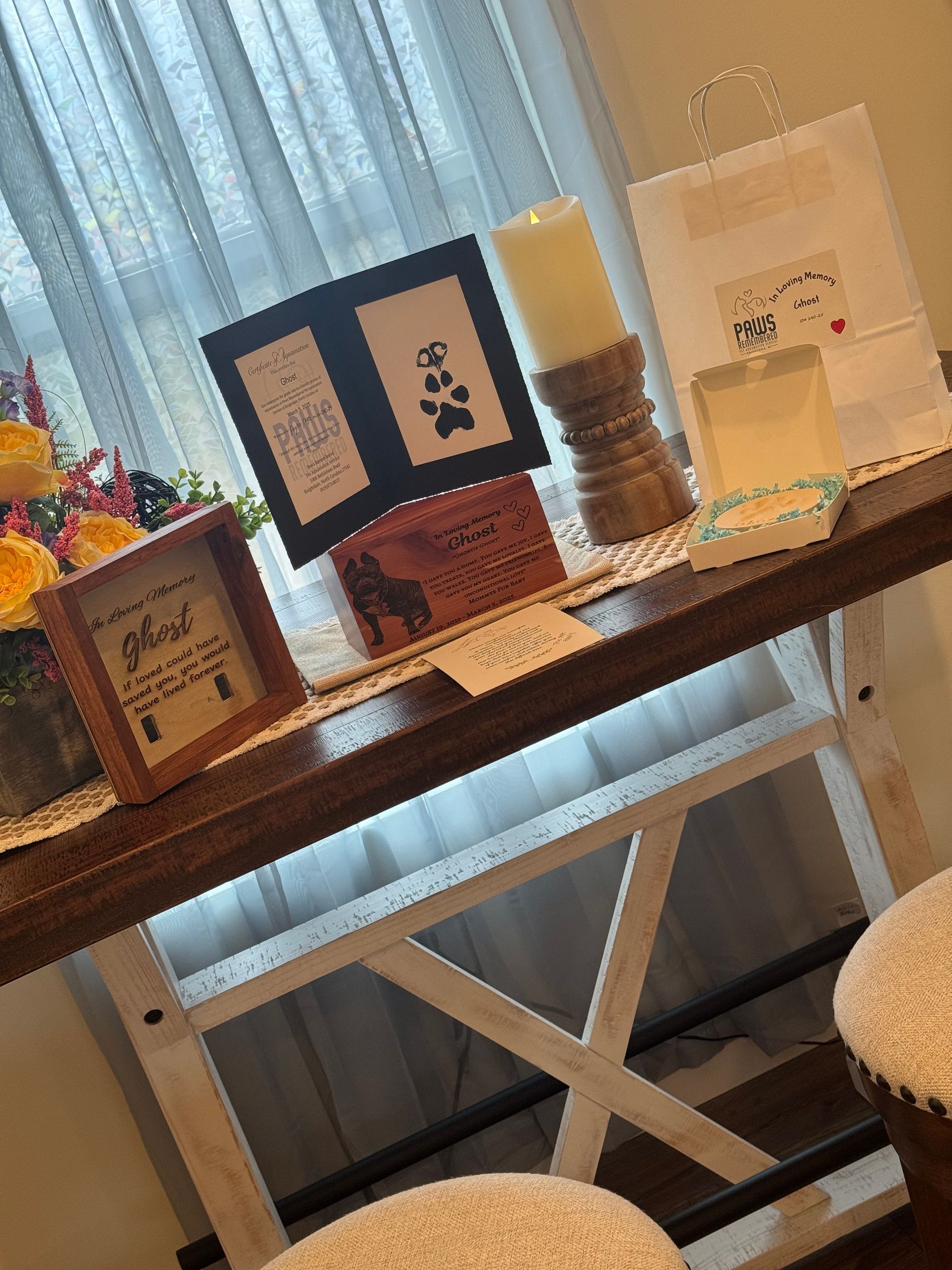 A wooden table with a candle and a picture frame on it.