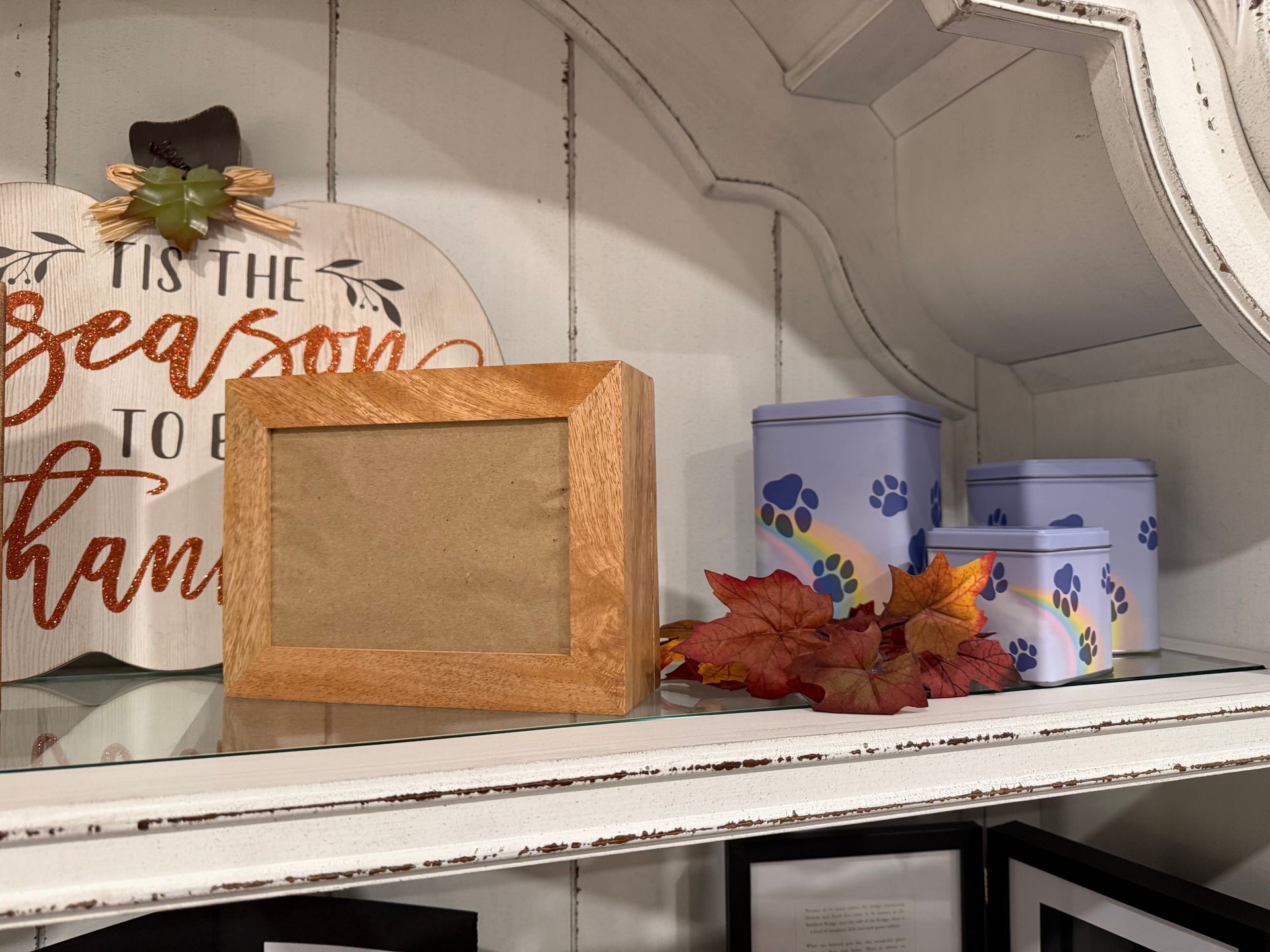 A picture frame is sitting on a shelf next to a sign that says tis the season to be thankful.