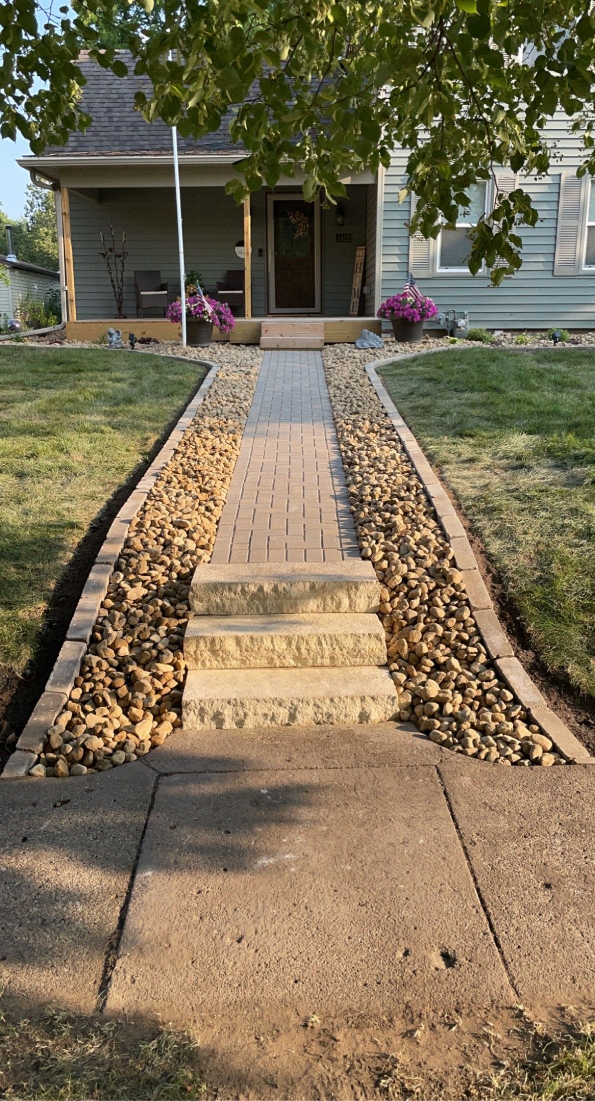 A shovel is sitting on the side of a concrete driveway.