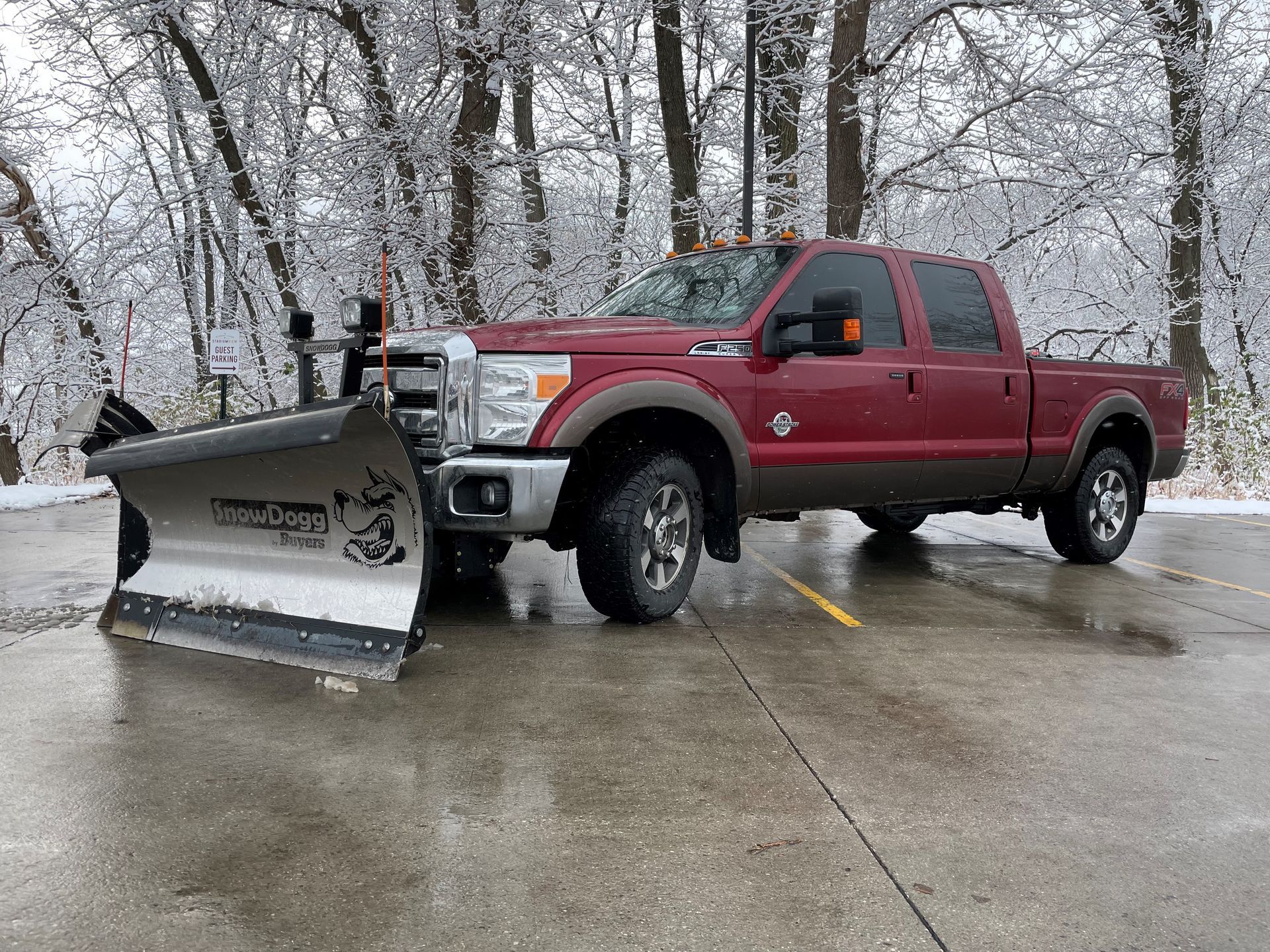 A yellow snow plow is driving down a snowy road.