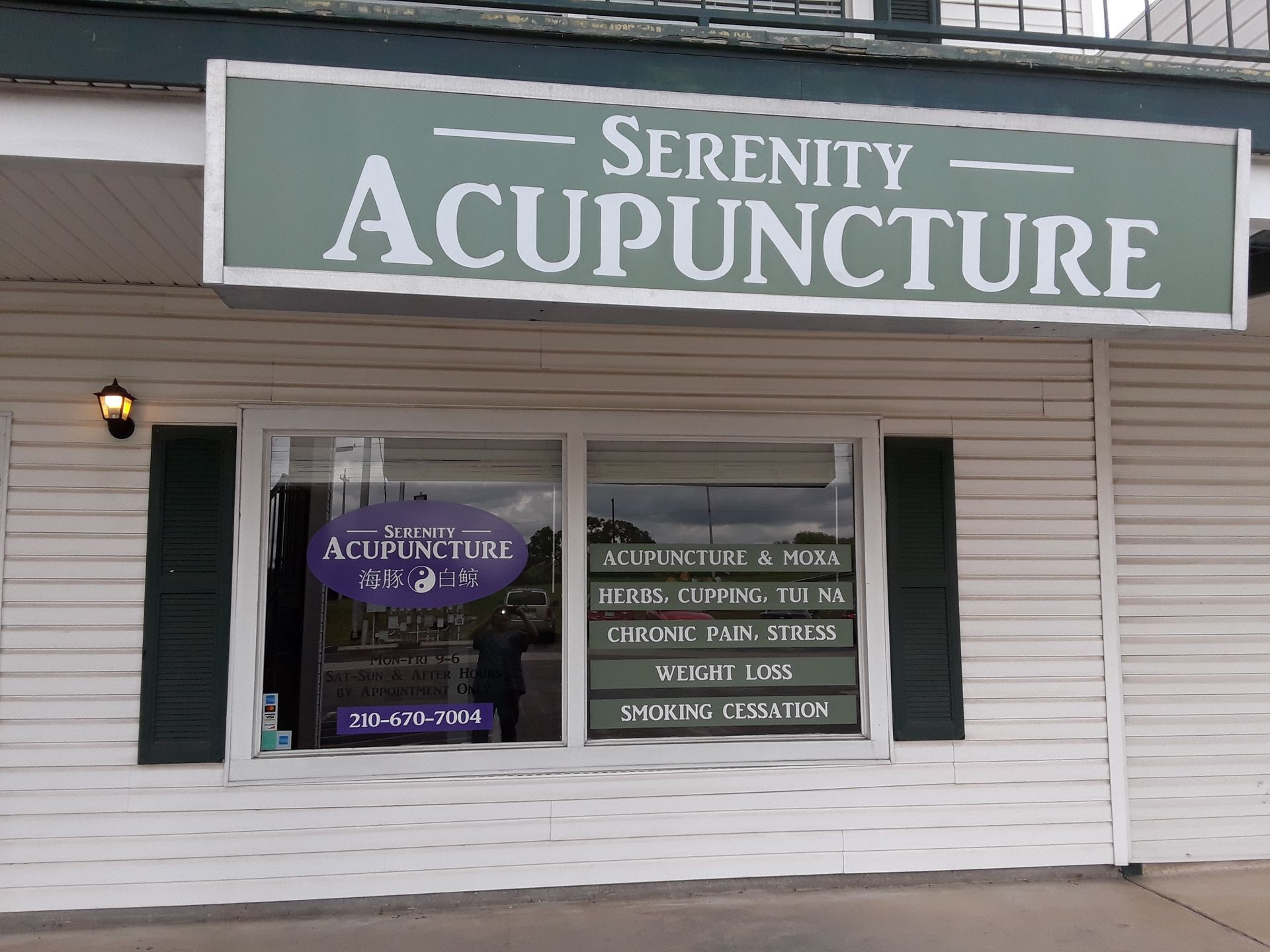 A sign for serenity acupuncture is above a window