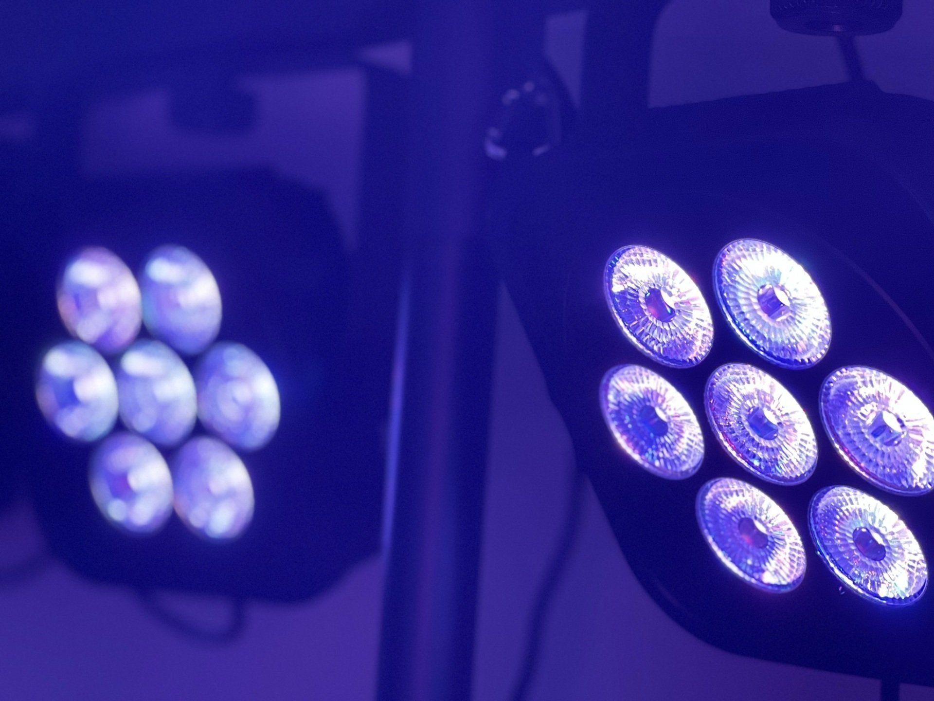 A close up of two purple lights in a dark room.