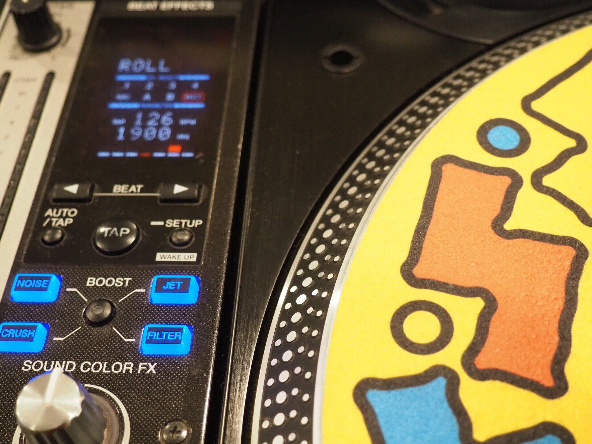 A close up of a turntable with a screen that says roll