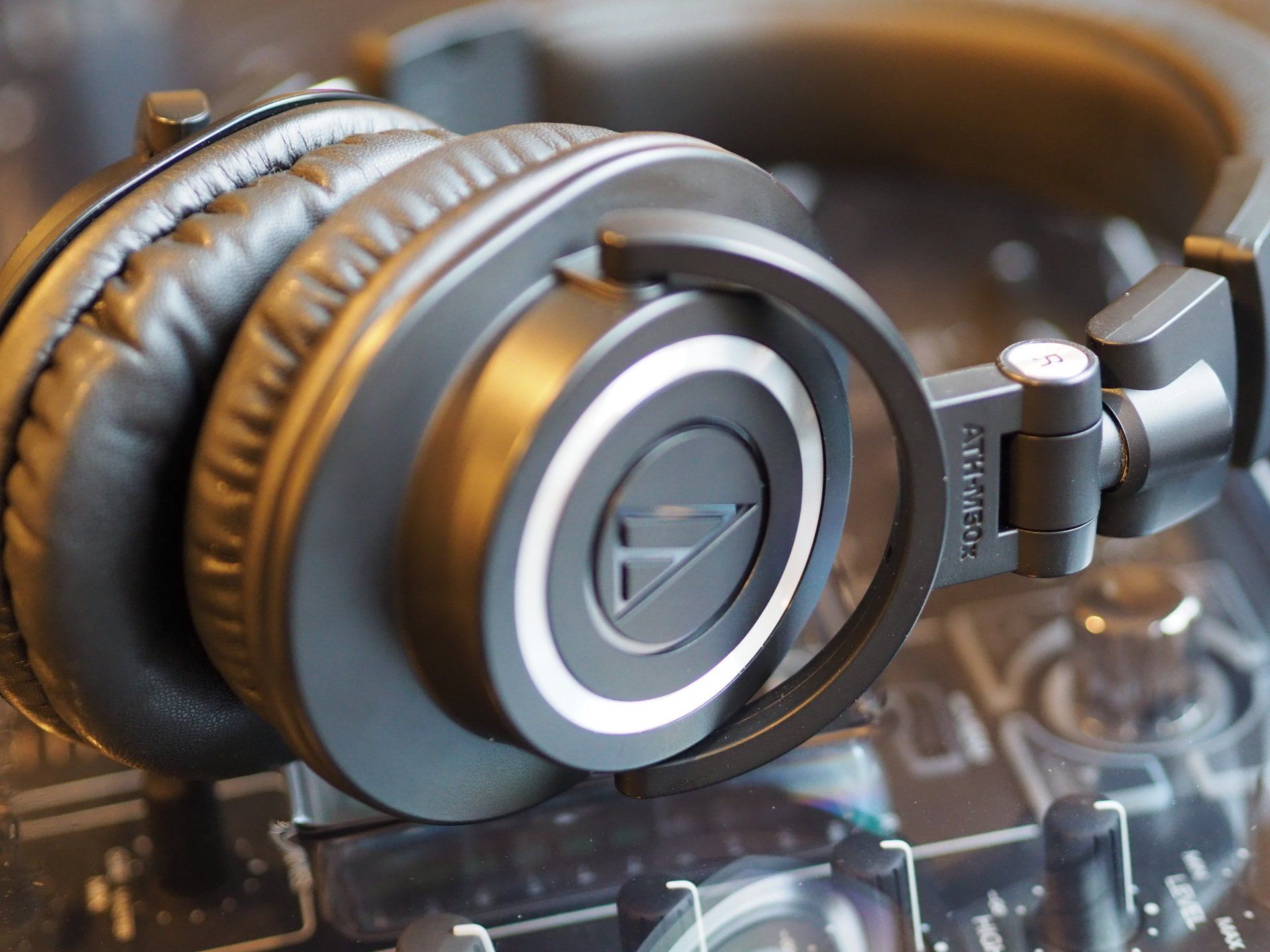 A pair of headphones are sitting on top of a mixer.