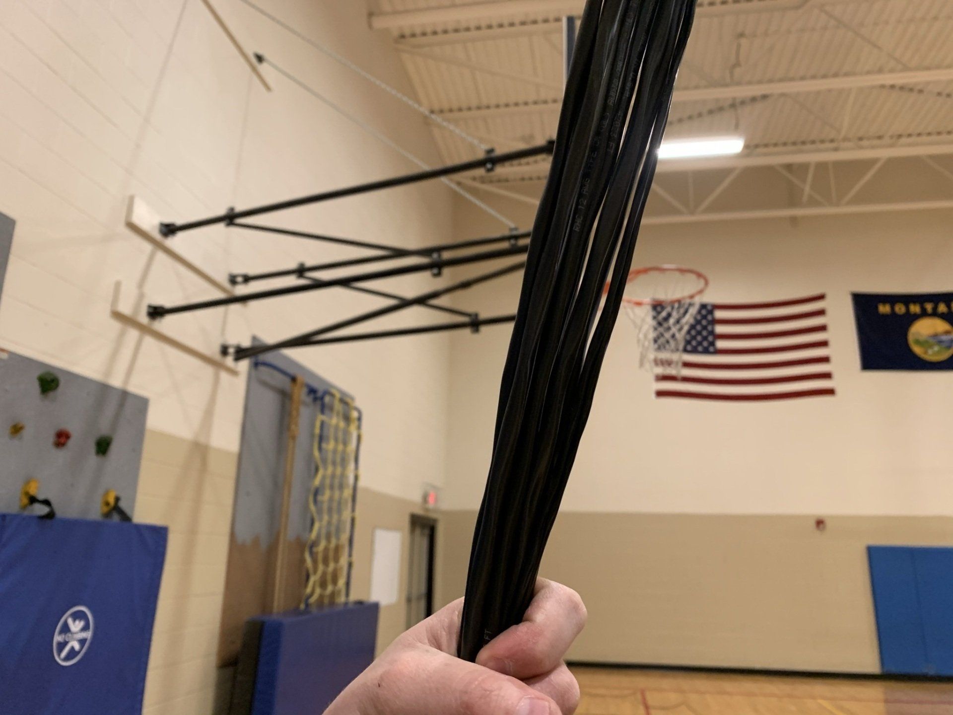 A person is holding a bundle of cables in a gym