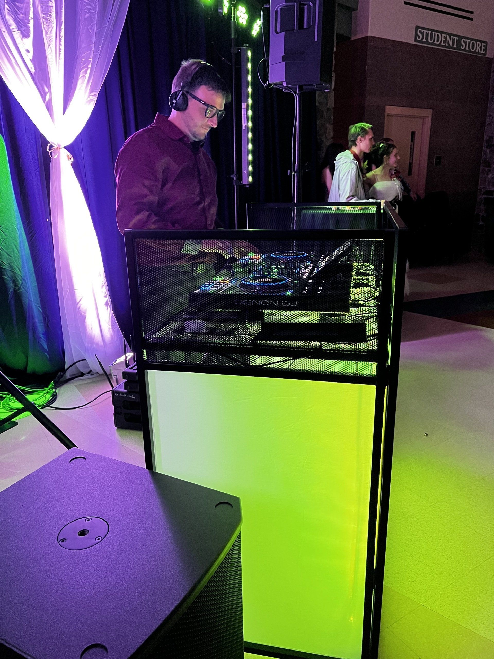 A man wearing headphones is playing music at a party