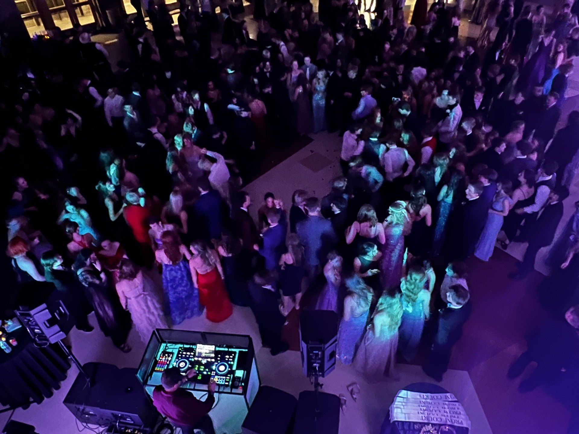 A large crowd of people are dancing at a prom party.