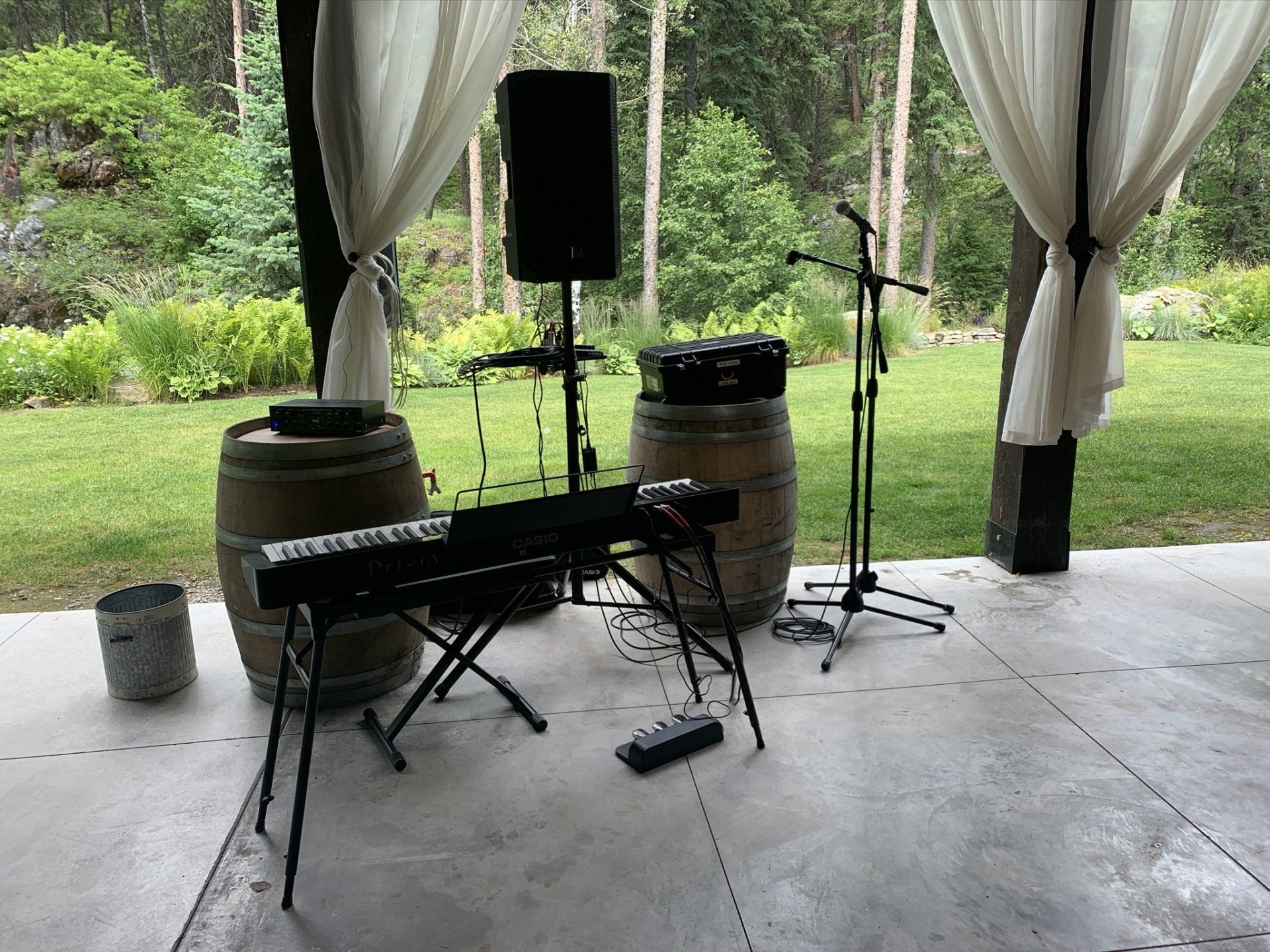 A keyboard and drums are sitting on a stage under a canopy.