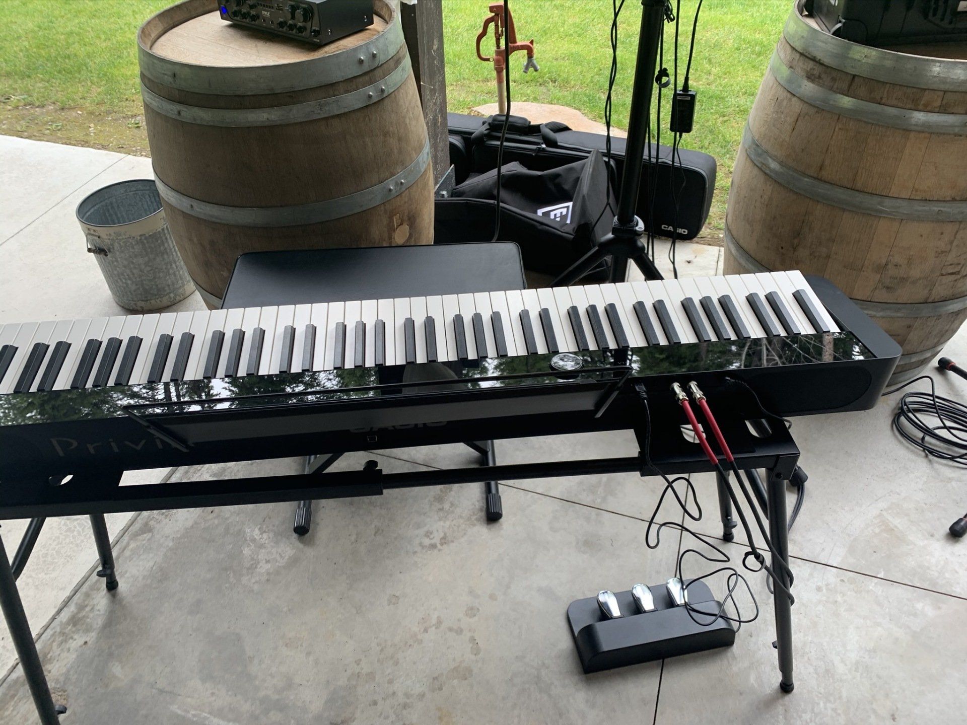 A piano keyboard is sitting on a table next to wooden barrels.