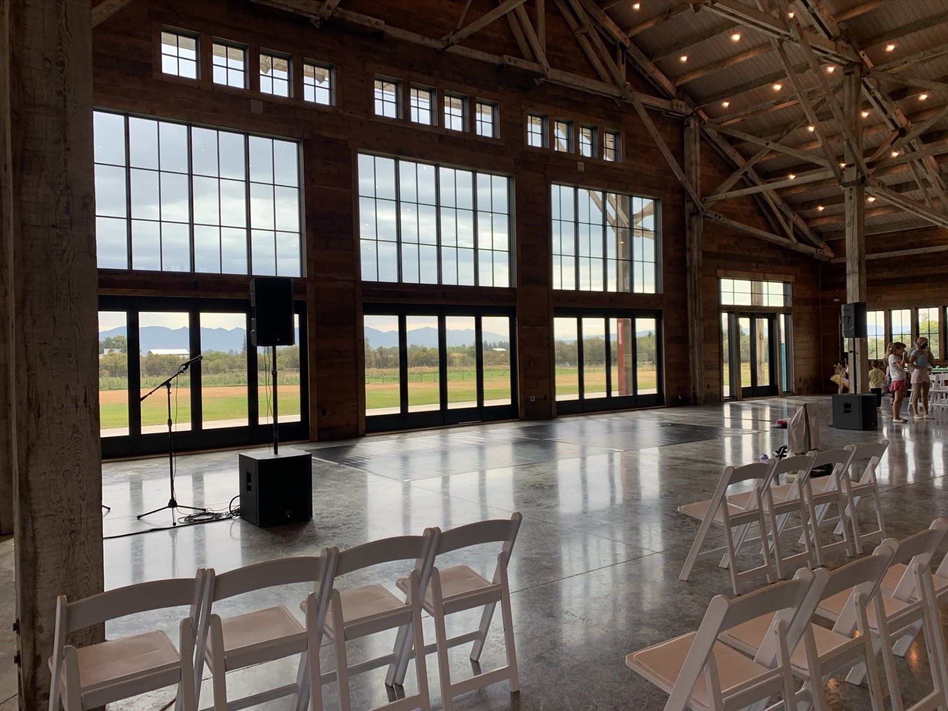 A large room with a lot of windows and white chairs.