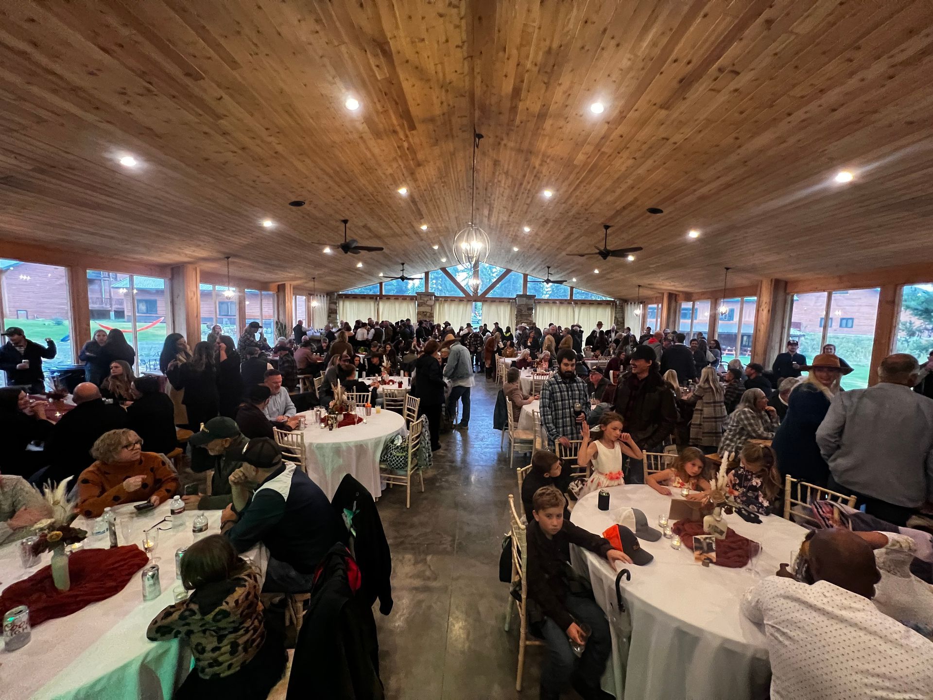 A large group of people are sitting at tables in a large room.