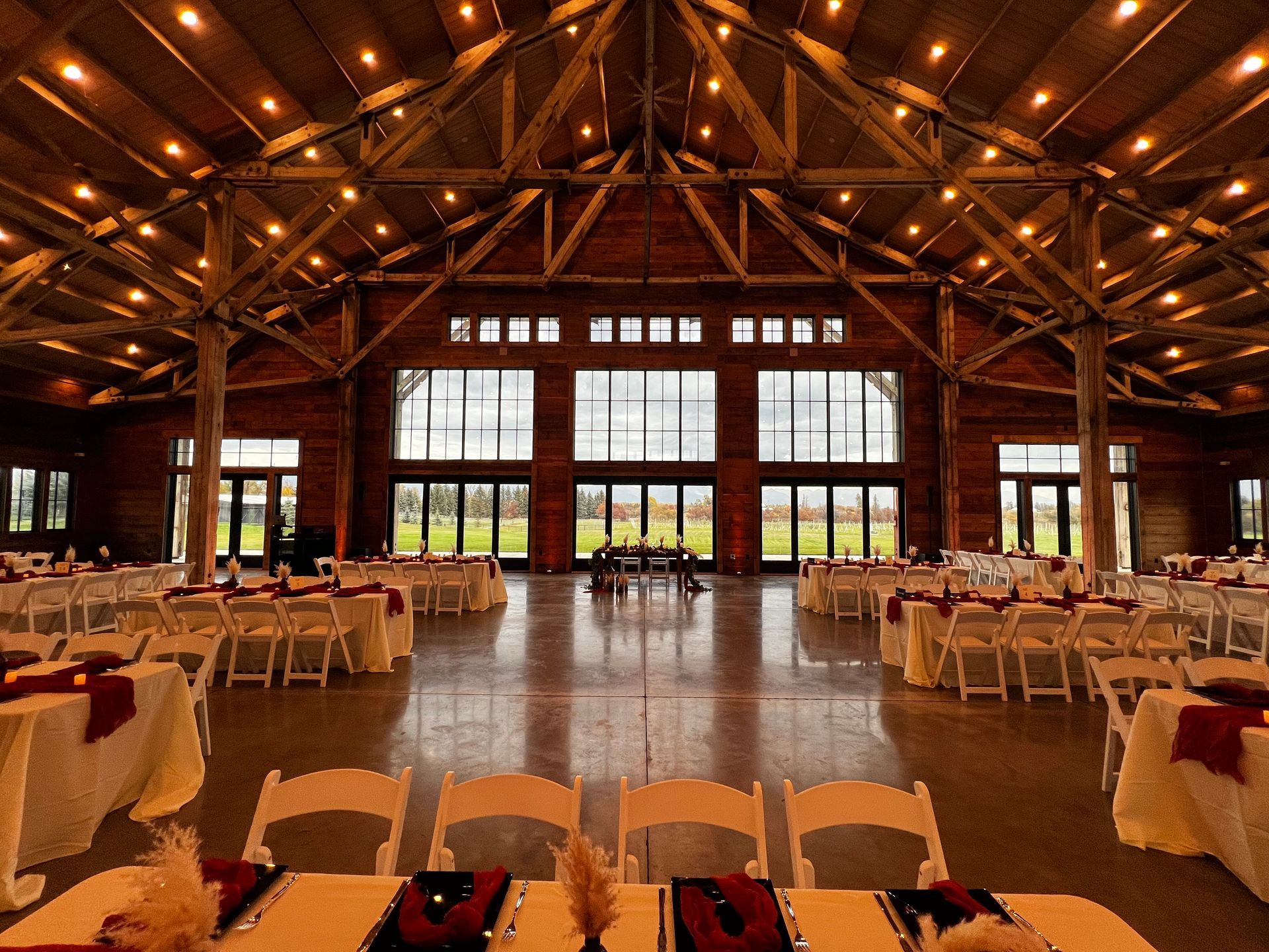 A large room with tables and chairs set up for a wedding reception