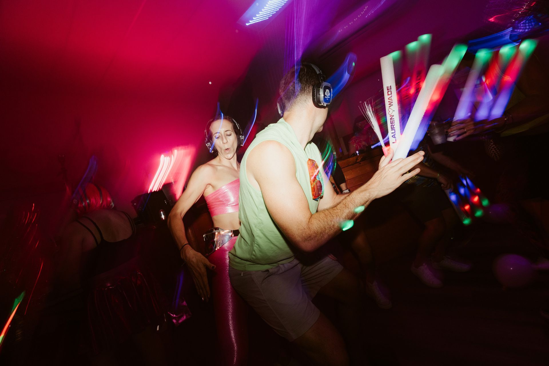 A man and a woman are dancing in a dark room at a party.