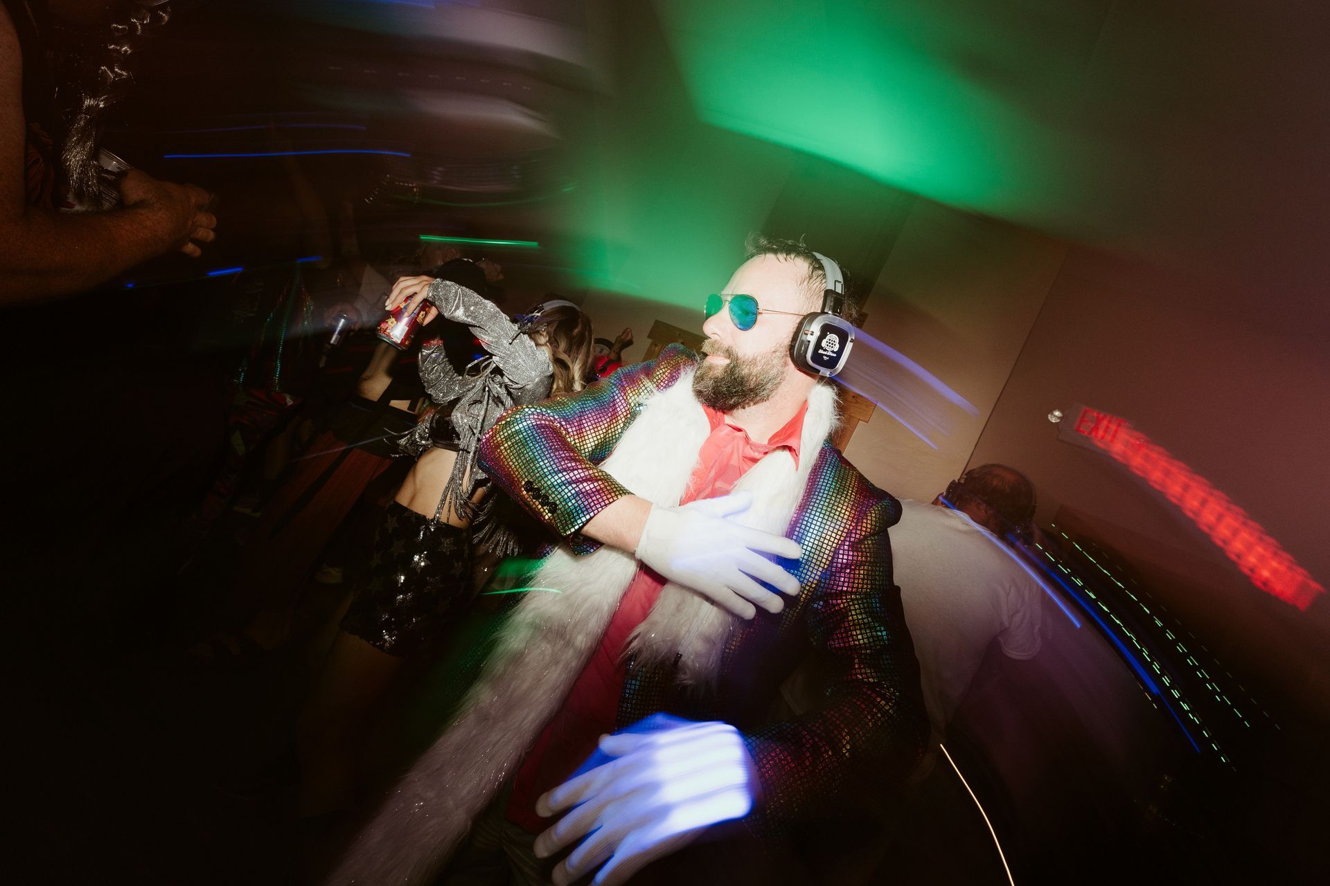 A group of people are dancing in a dark room with blue lights.