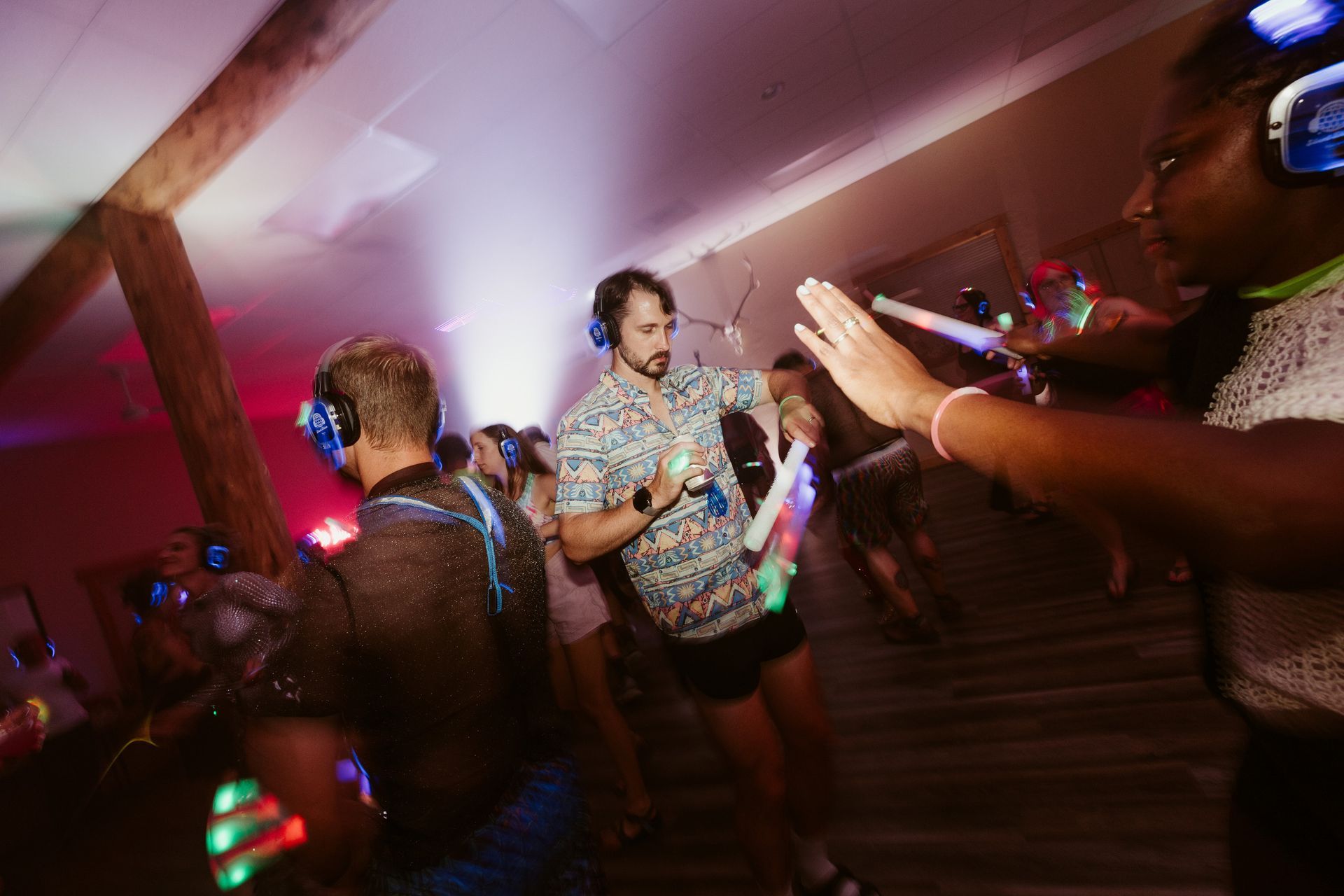 A man in a palm tree shirt is taking a picture of himself