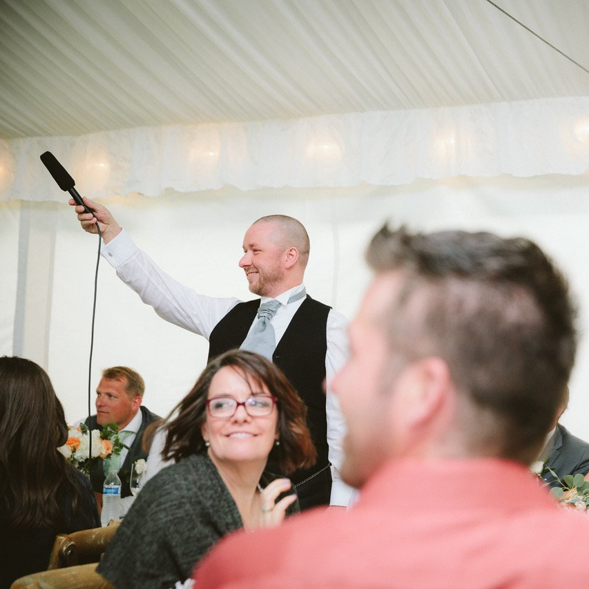 A man is holding a microphone in front of a group of people