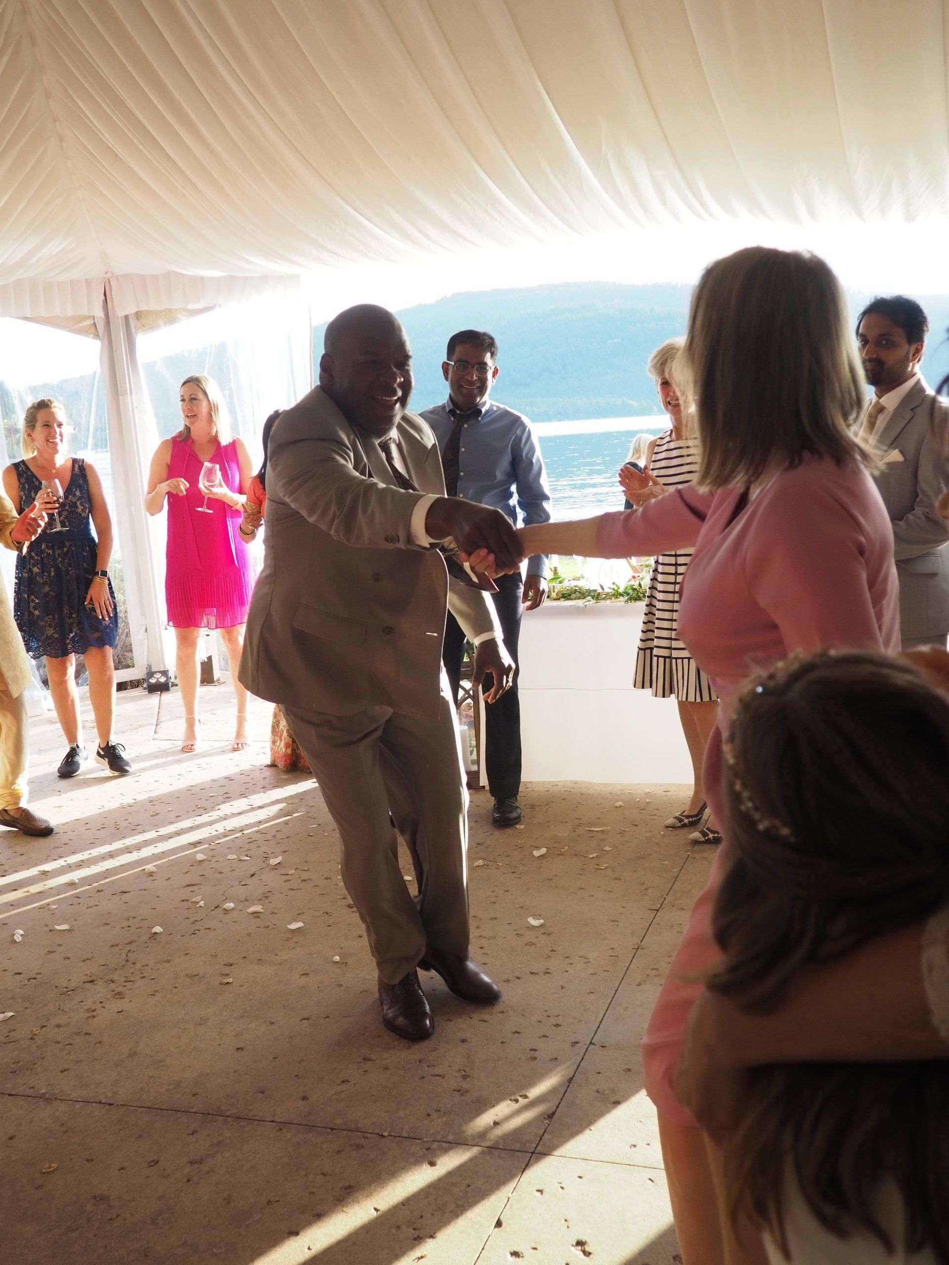 A group of people are dancing under a tent.