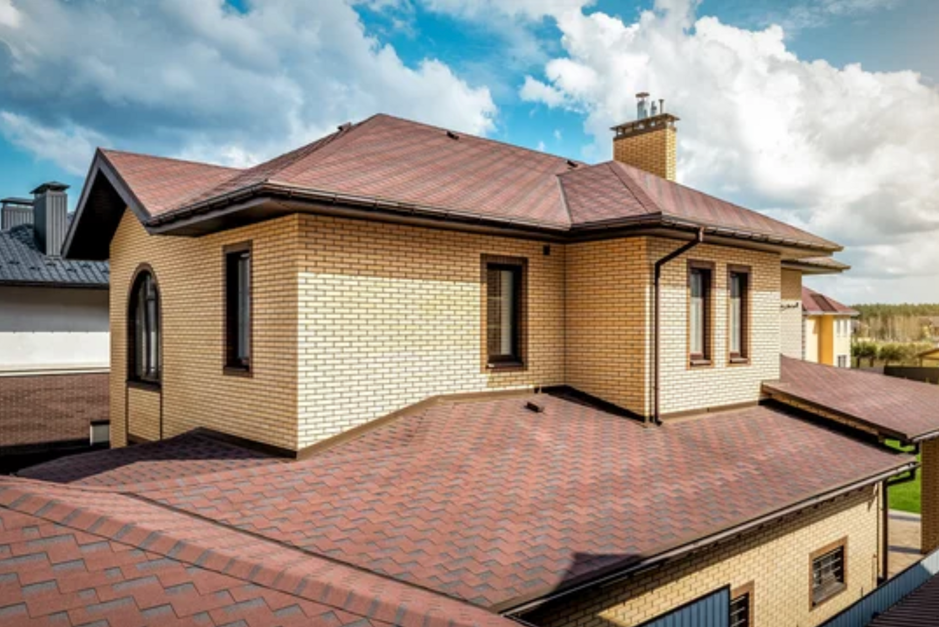 AD Construction NJ - Brick house with a red roof under a cloudy sky.