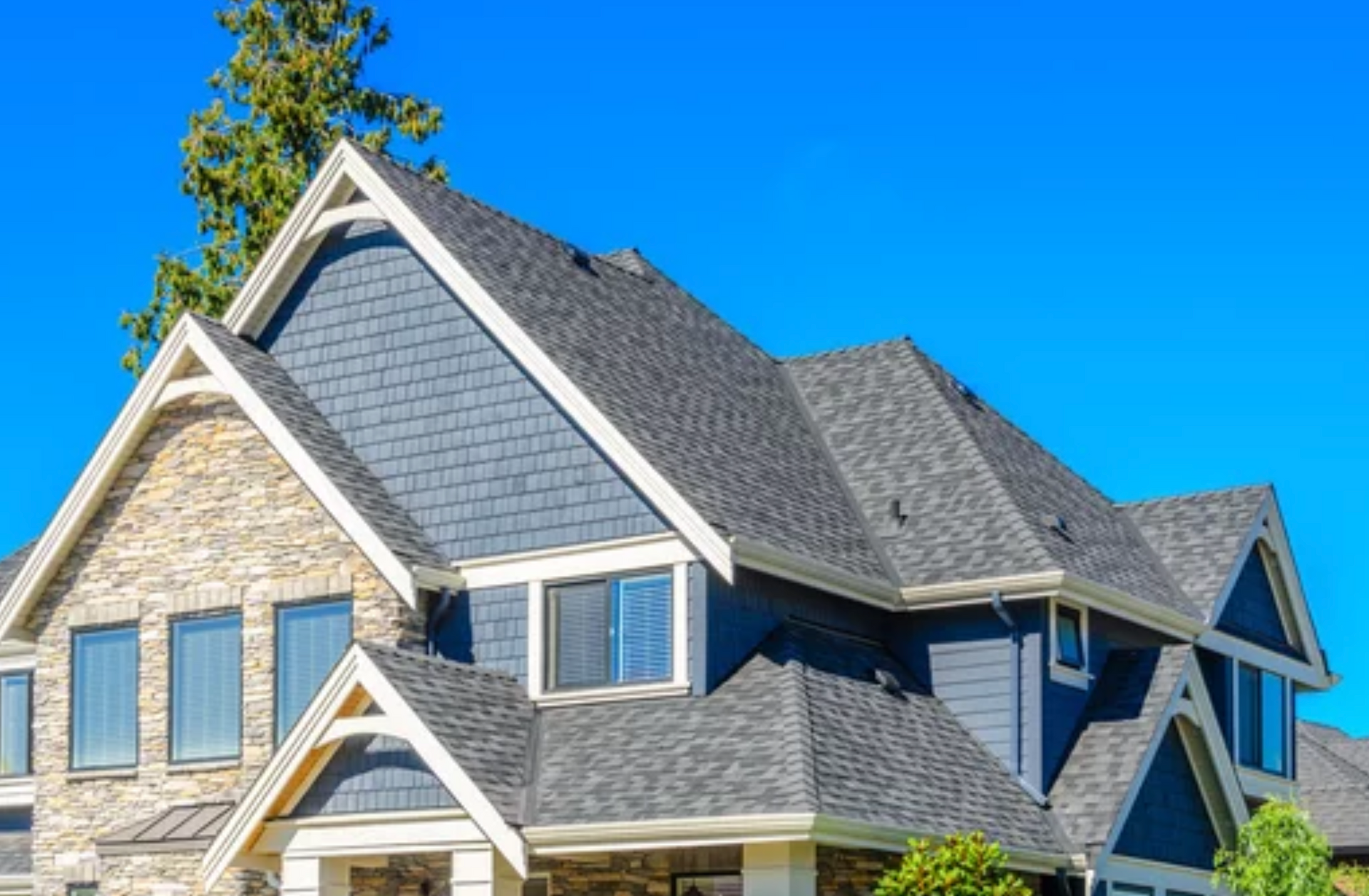 AD Construction NJ - House with blue siding and gray roof against a clear, blue sky.