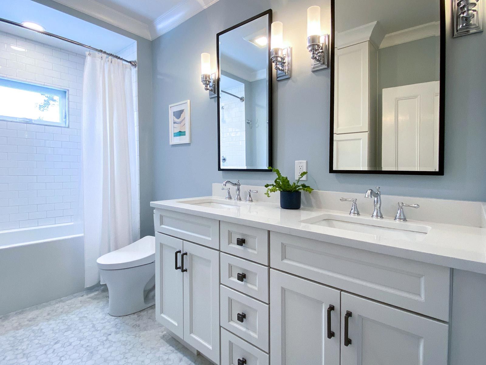 AD Construction NJ - Bathroom with white double vanity, mirrors, and light blue walls.