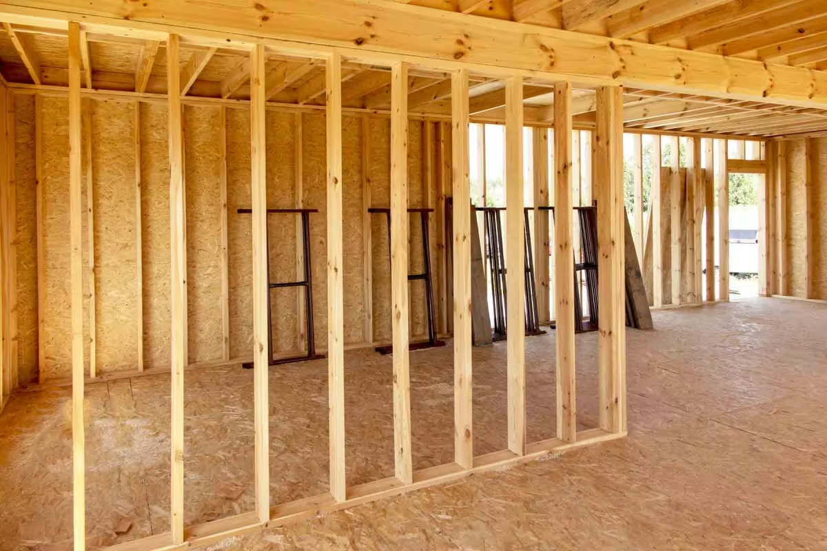 AD Construction NJ - Interior view of a building under construction, showing wooden framing for walls and ceiling.