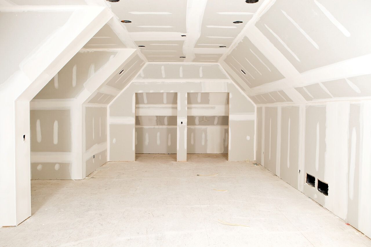 AD Construction NJ - Interior room under construction with white drywall and recessed storage spaces.