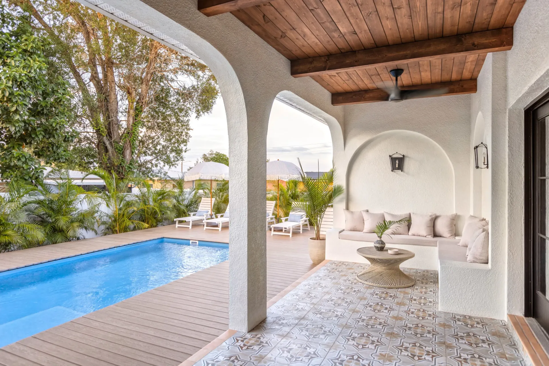 AD Construction NJ - Poolside patio with arched openings, seating, and a small pool.