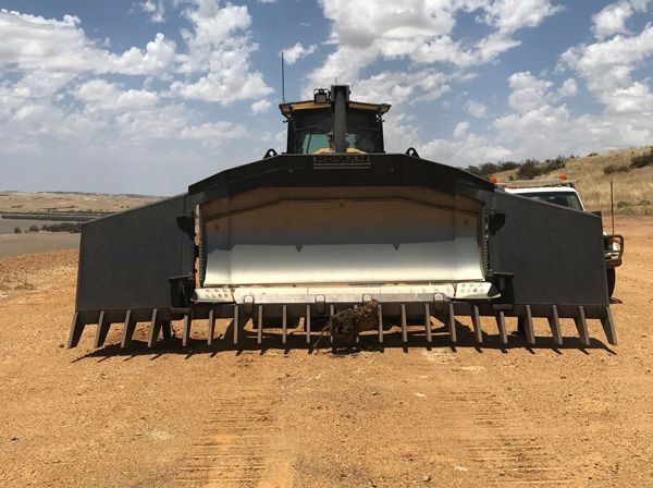 A large hole in the ground with trees in the background.