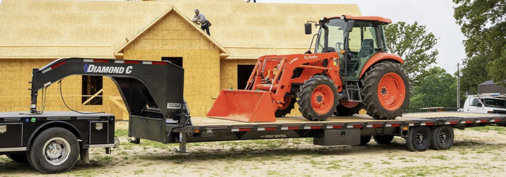 A tractor is sitting on top of a flatbed trailer.