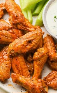 Pile of golden-brown chicken wings, coated in parmesan and herbs, in a basket.