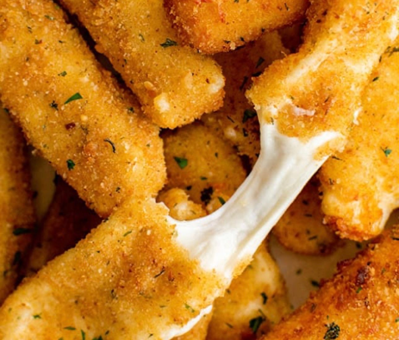 French fries in paper cone with cheese and bacon.