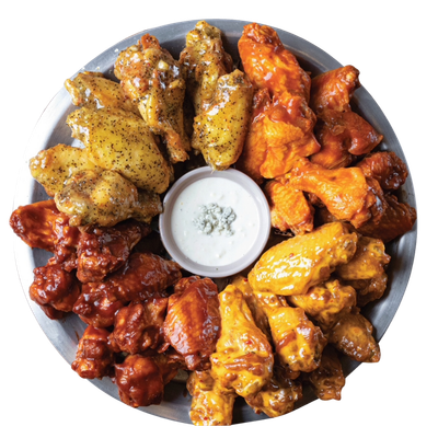 A platter of various chicken wings with dipping sauce in the center.