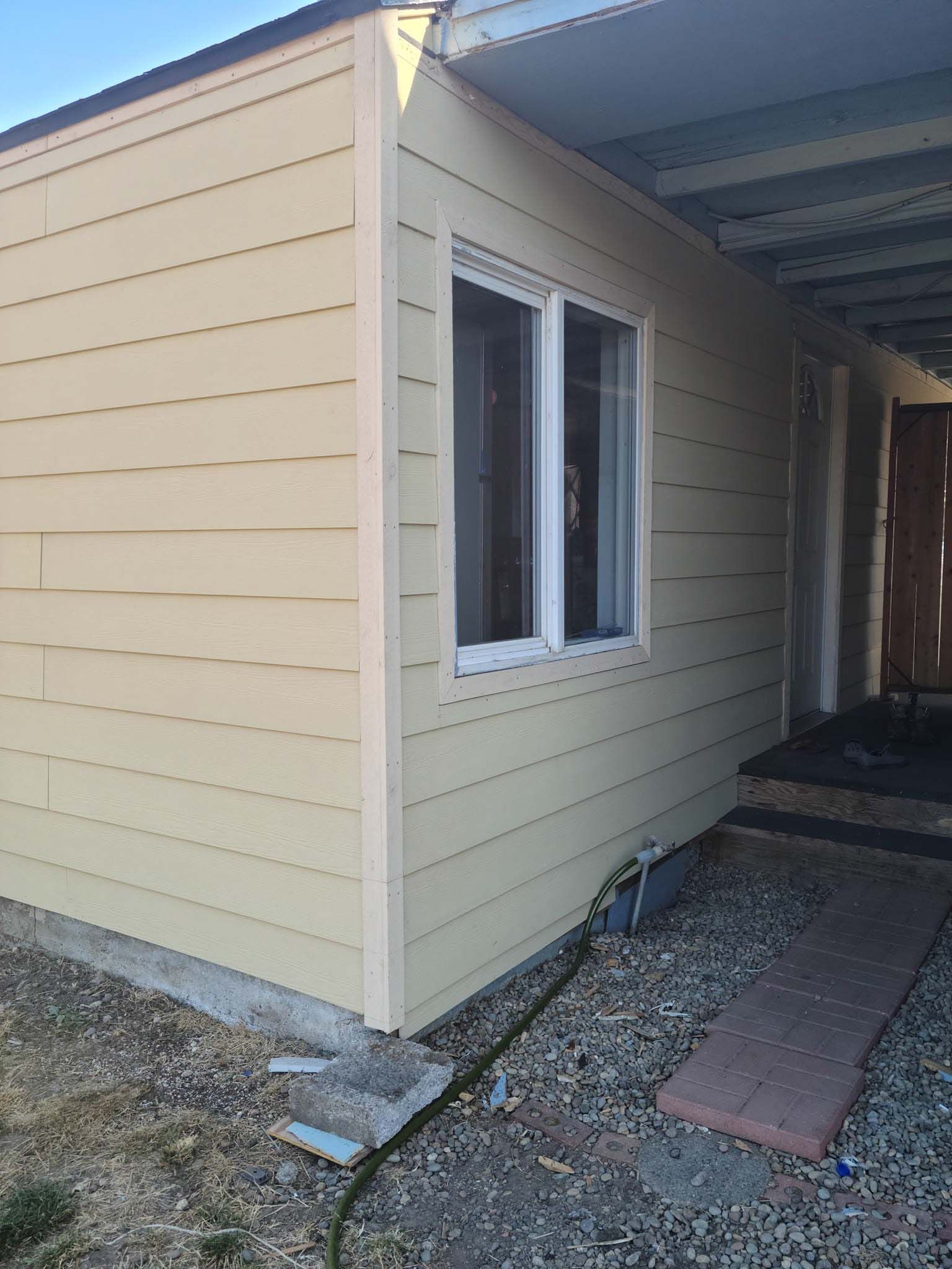 The side of a house with a window and a door.