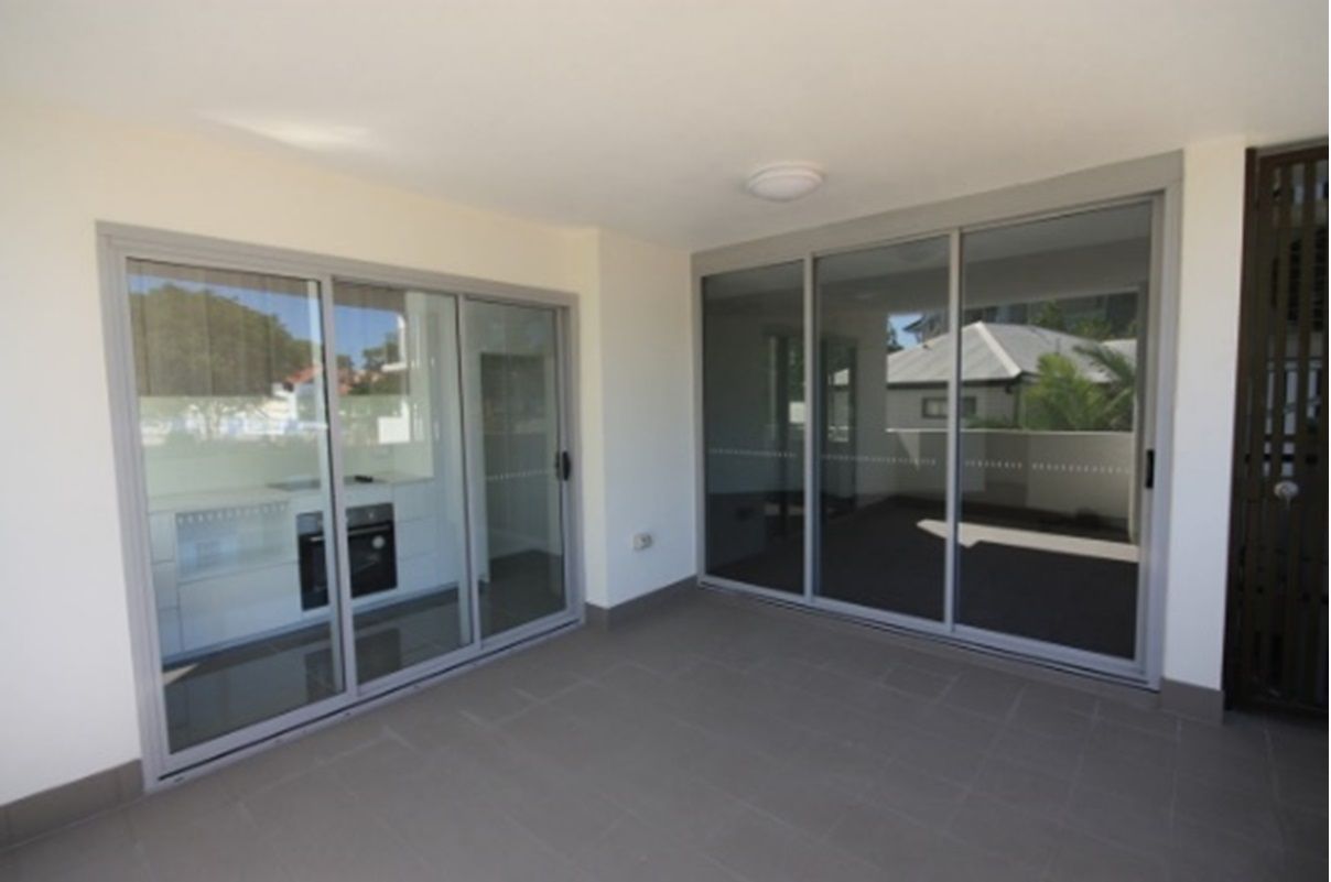 An Empty Room With Sliding Glass Doors Leading To A Balcony — Datco Aluminium Pty Ltd In Murwillumbah, NSW