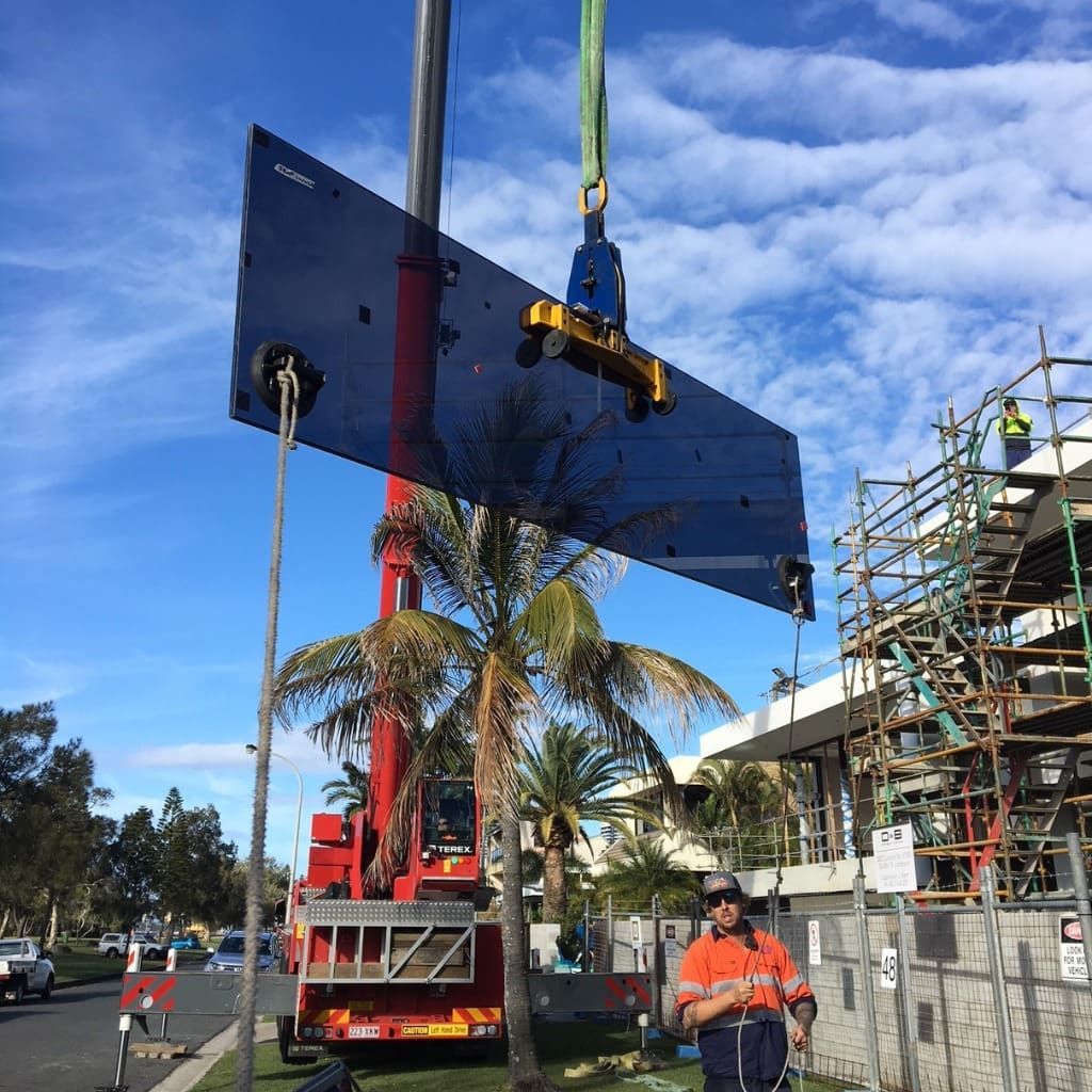 A Large Piece Of Glass Is Being Lifted By A Crane — Datco Aluminium Pty Ltd In Murwillumbah, NSW