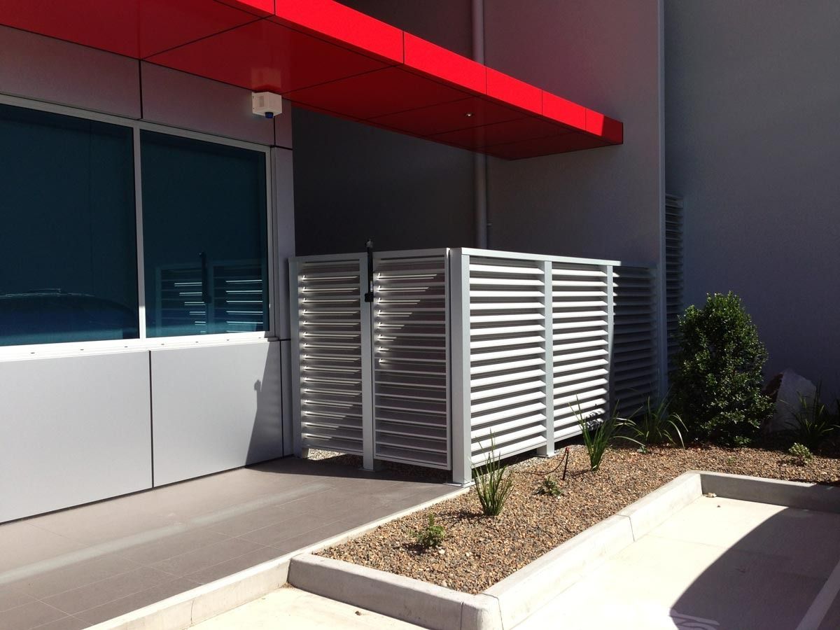 A Building With A Red Awning And A White Fence — Datco Aluminium Pty Ltd In Byron Bay, NSW