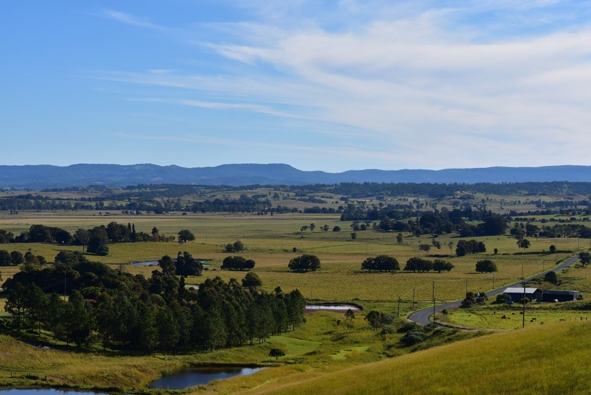 There Is A Lake In The Middle Of A Field With Mountains In The Background — Datco Aluminium Pty Ltd In Kyogle, City