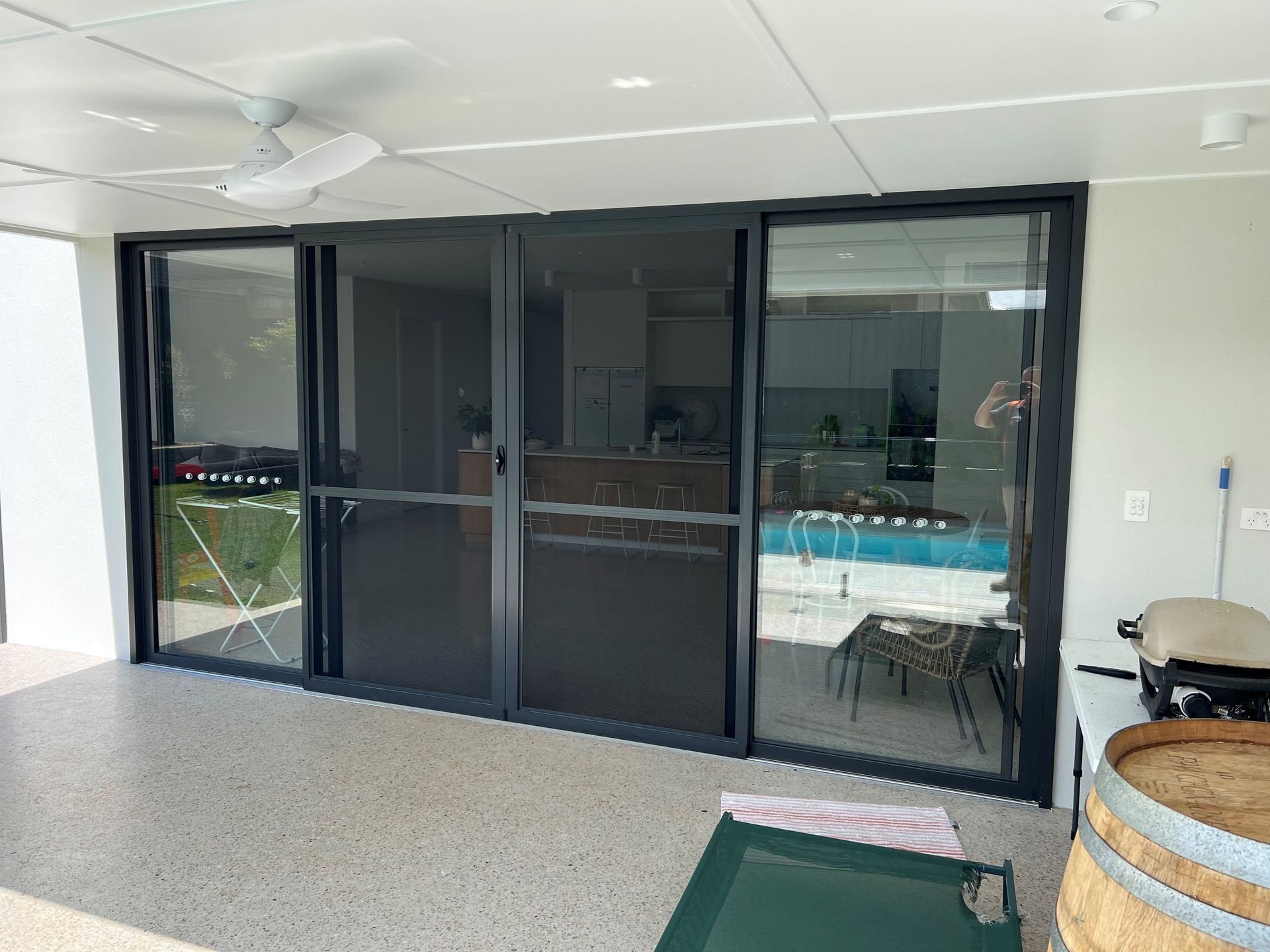 A Patio With Sliding Glass Doors and a Ceiling Fan — Datco Aluminium Pty Ltd In Murwillumbah, NSW