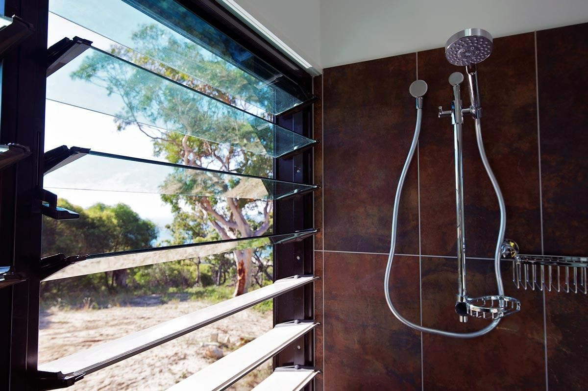 A Bathroom With A Shower And A Window With Shutters — Datco Aluminium Pty Ltd In Murwillumbah, NSW