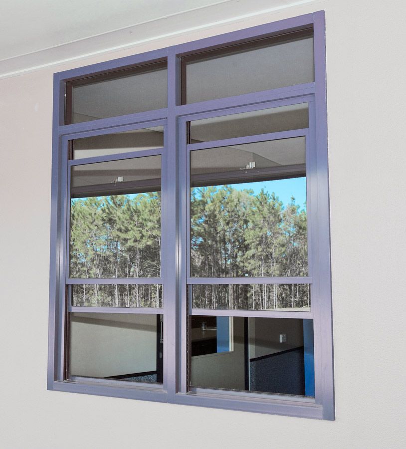 A Purple Window With A Reflection Of Trees In It — Datco Aluminium Pty Ltd In Murwillumbah, NSW