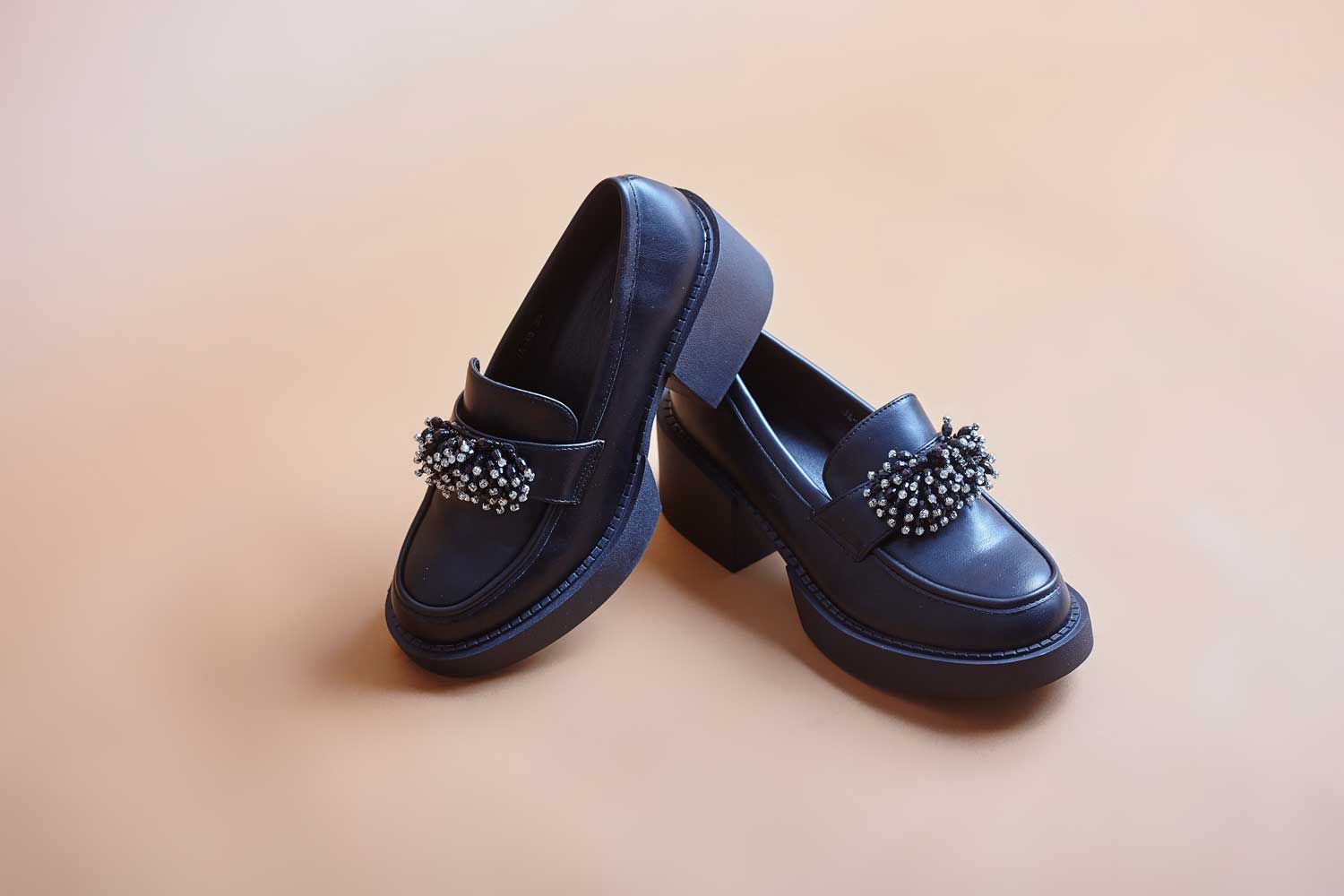 Mocassins noir avec semelle épaisse et talon plat.