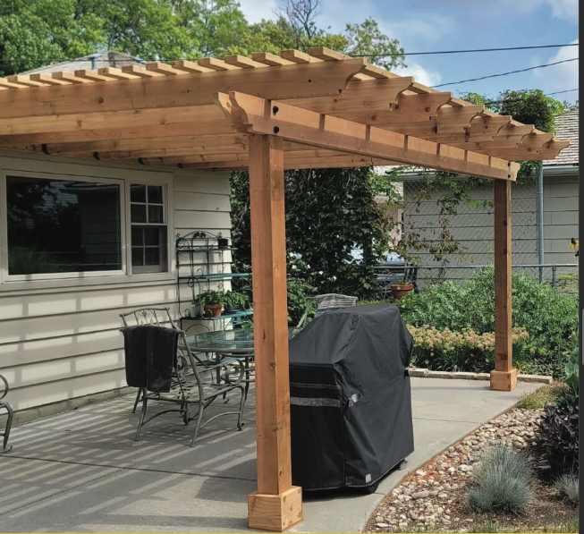 A wooden pergola with a fire pit underneath it