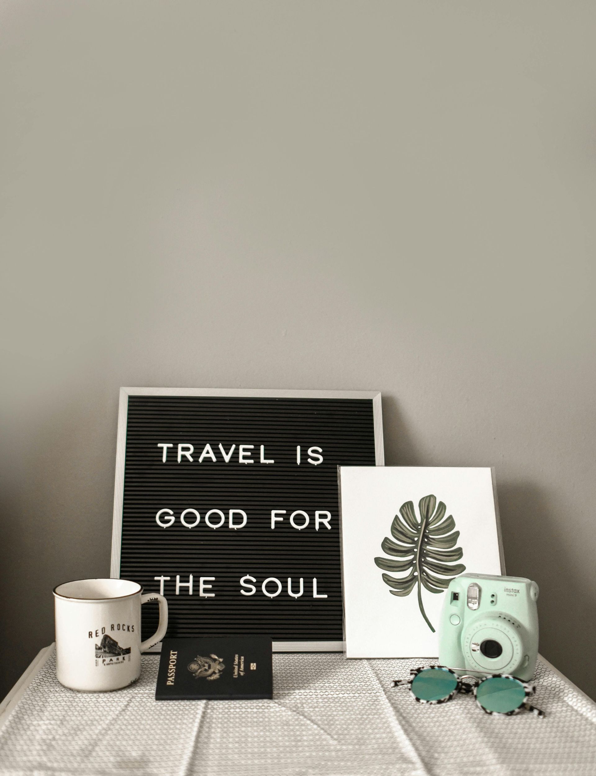 A sign that says `` travel is good for the soul '' is sitting on a table.