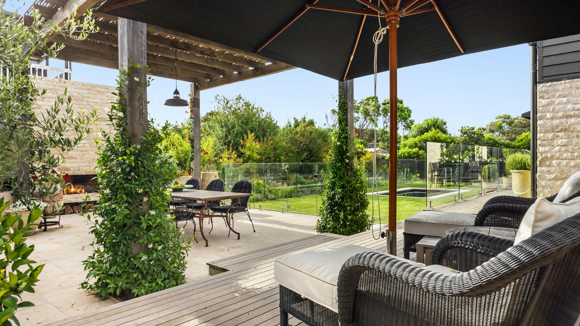 Patio with dining set, lounge chairs, pergola, and outdoor fireplace.